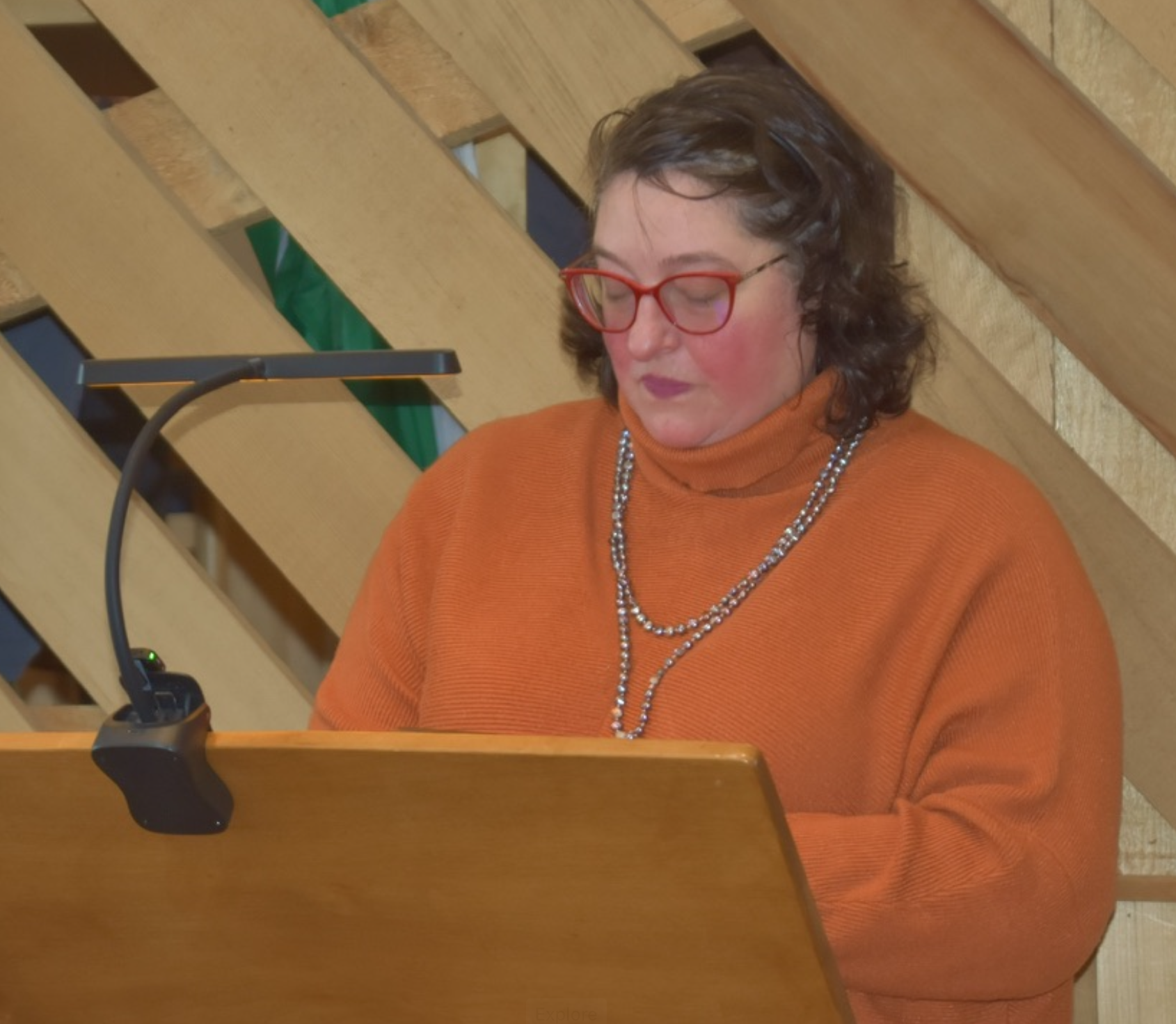 Vanessa speaking at a lectern with a microphone