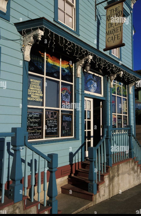 The Record Deli Market Cafe — blue Victorian storefront with chalkboard signs, string lights, and porch in Point Arena