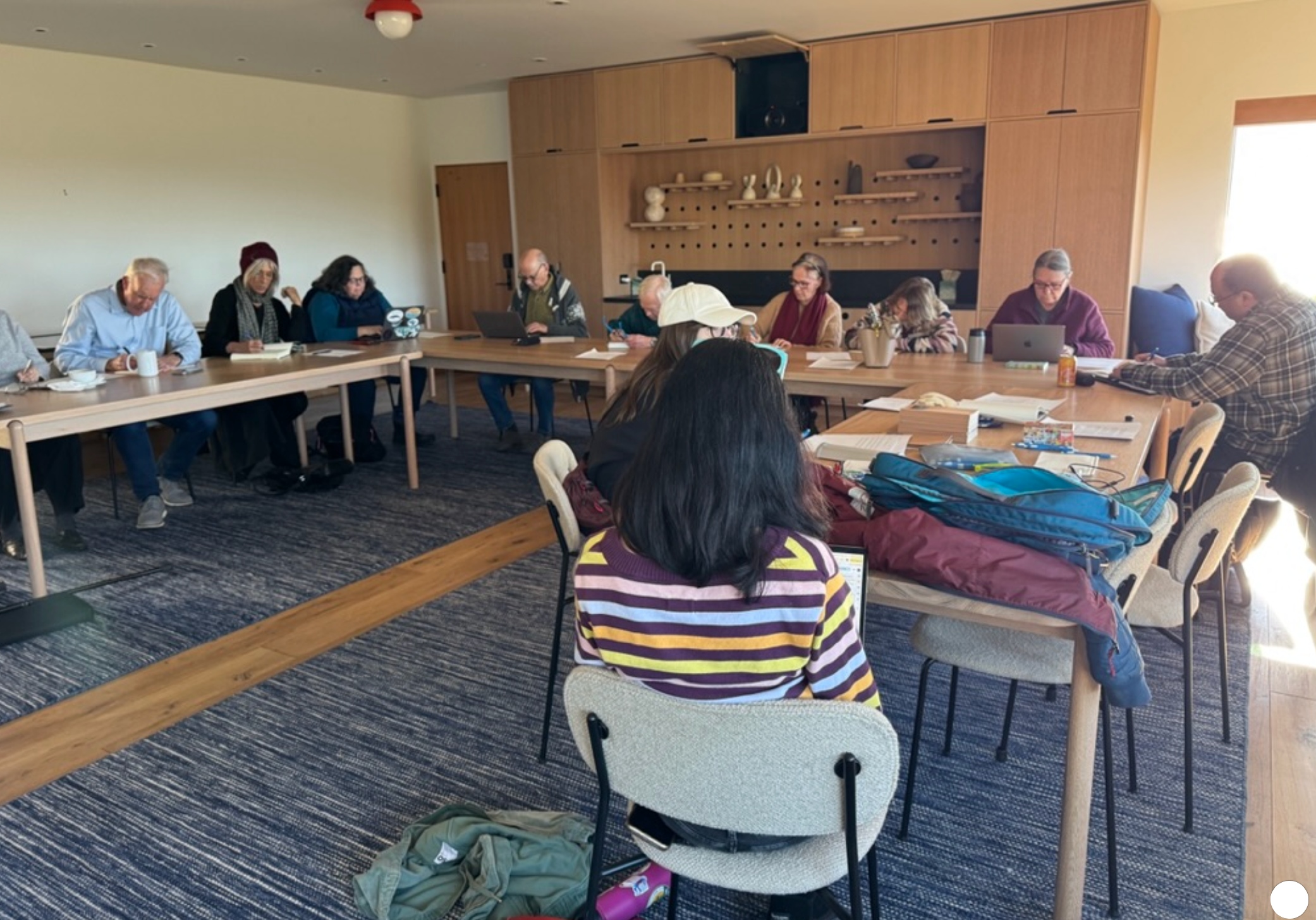 A Write Now! gathering — a dozen writers around tables in the lodge room, notebooks and laptops open