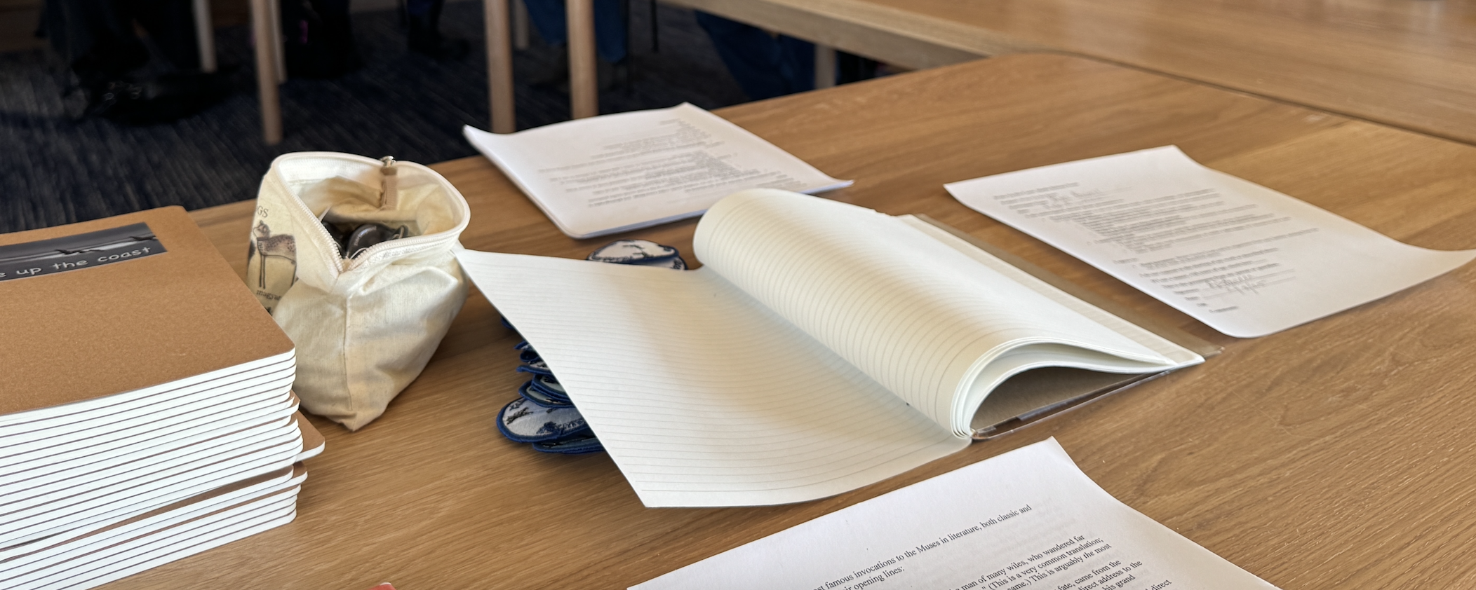 Workshop table with notebooks, open journal, and papers